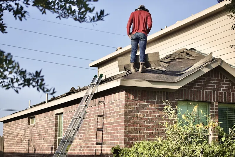 Professional roofer working on a residential roof in Greenfield Hill